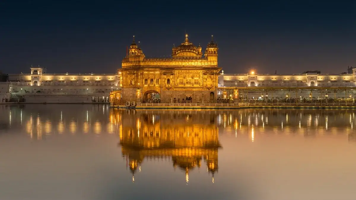 The illuminated Golden Temple reflects beautifully on the sacred Amrit Sarovar pool at night.