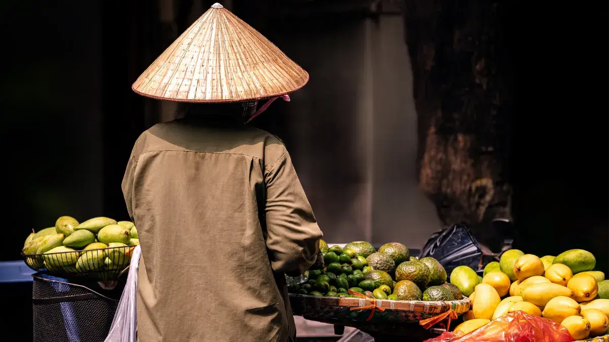 A Vietnamese street vendor offering an assortment of tropical fruits on bicycle