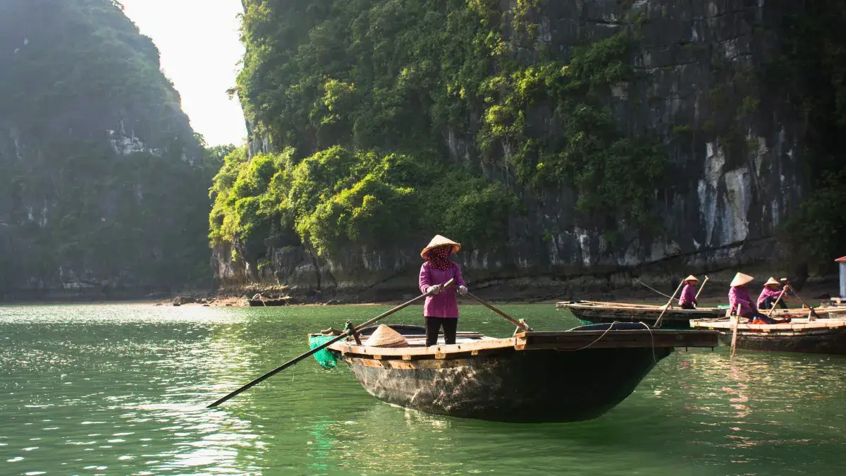 Rowing boat on Tam Coc river winding through limestone karsts