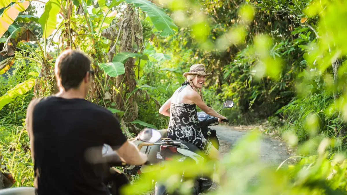 Scooters being ridden on scenic Bali road