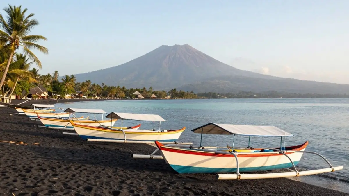 Traditional fishing boats on Amed black sand beach with Mount Agung