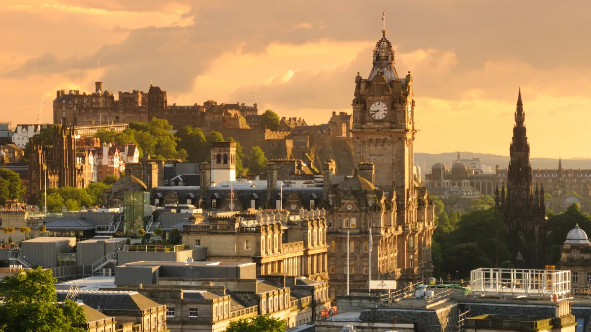 Edinburgh skyline at sunset with the Balmoral Hotel clock tower and Edinburgh Castle in the background