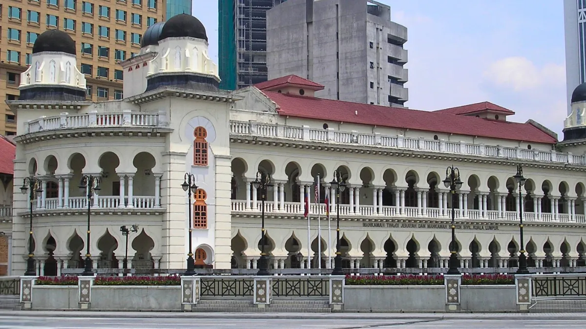 Historic courthouse building with arched colonnades and domed towers in a city center