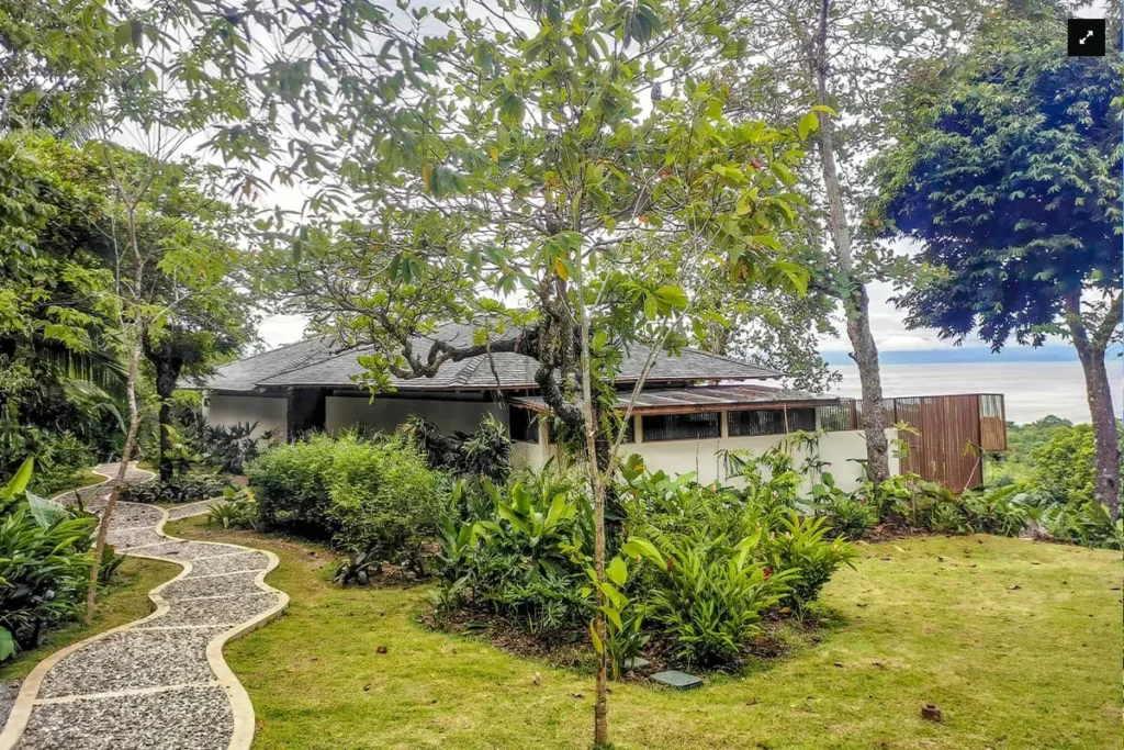 Tropical garden path leading to a house with ocean view