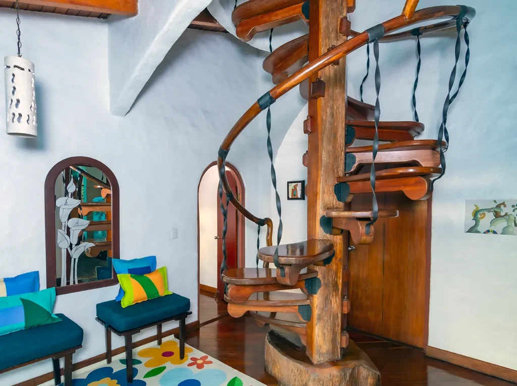 Interior with a wooden spiral staircase and colorful bench seating