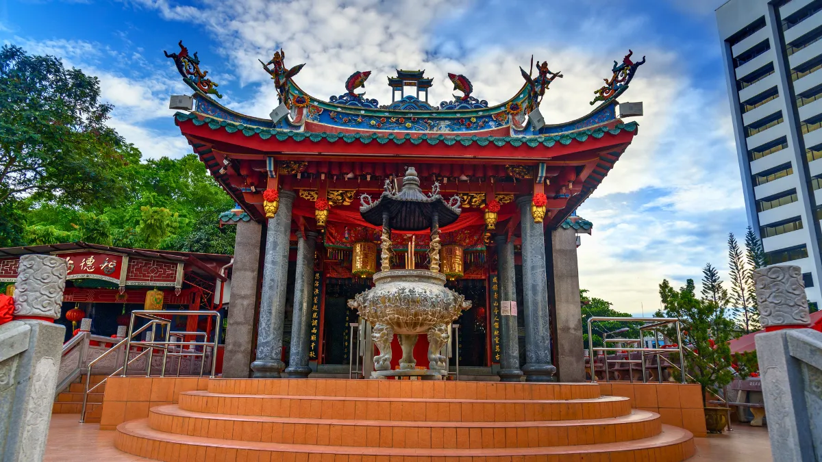 Ornate Chinese temple with a large incense burner in front
