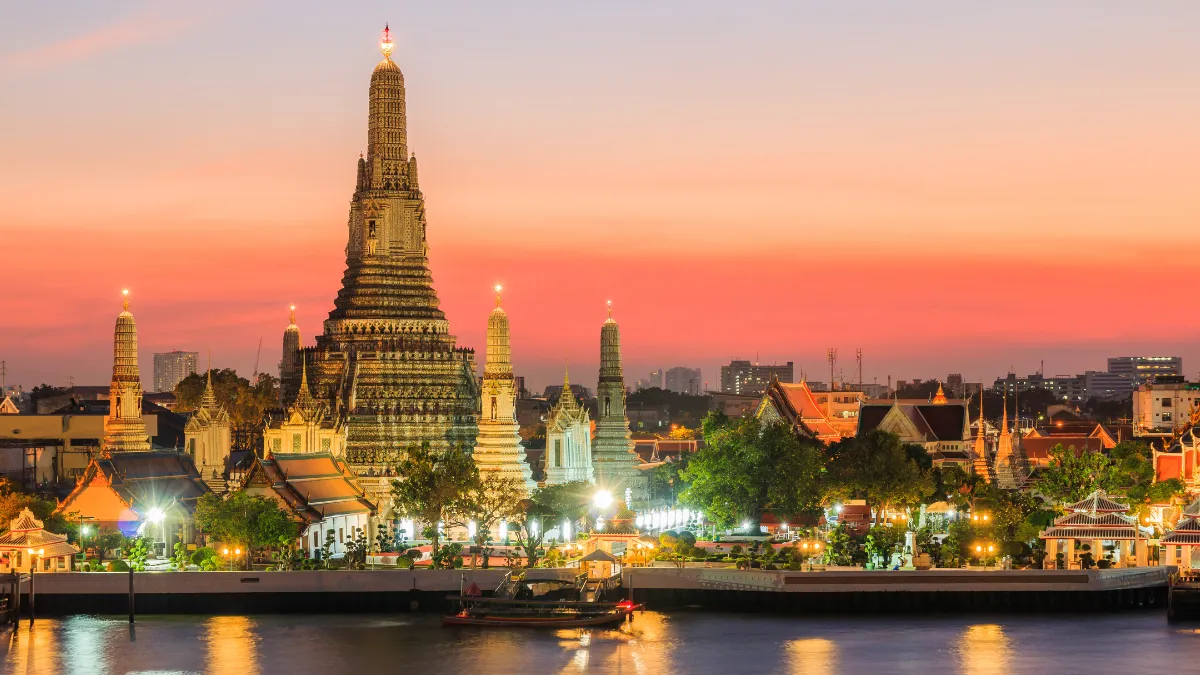 Wat Arun temple at sunset on the Chao Phraya River in Bangkok