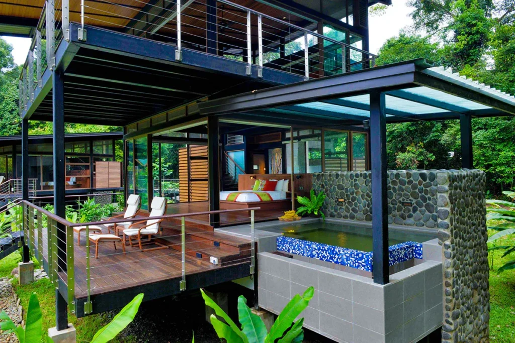 Modern tropical villa with a deck, lounge chairs, and a small private pool