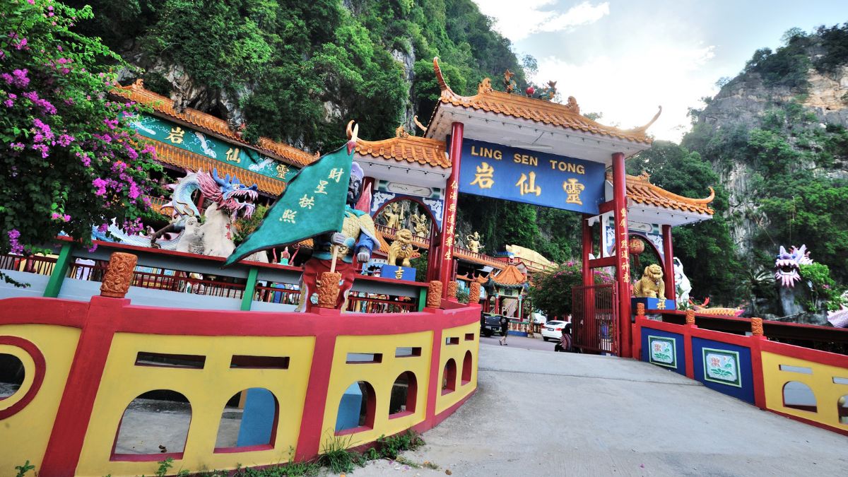 Entrance to Ling Sen Tong temple, a colorful Chinese shrine surrounded by limestone cliffs and tropical greenery Ipoh Travel Guide