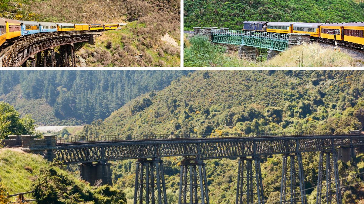 A yellow passenger train crosses trestle bridges through a forested mountain valley